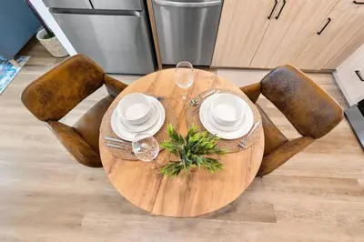 a wooden table with plates and wine glasses on it at 5 Star 1BR Apartment w/ Free Parking & Fast WiFi in Los Angeles