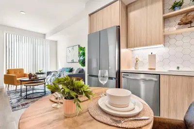 a kitchen with a wooden table with a glass of wine at 5 Star 1BR Apartment w/ Free Parking & Fast WiFi in Los Angeles