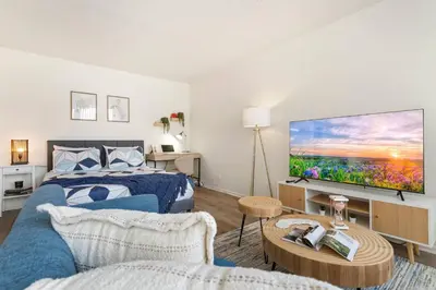 a bedroom with a bed and a flat screen tv at 5-star West Hollywood Living | Modern & Central in Los Angeles