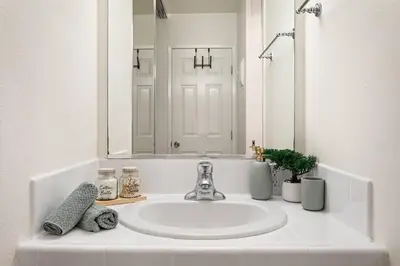 a white sink in a bathroom with a mirror at 5-star West Hollywood Living | Modern & Central in Los Angeles