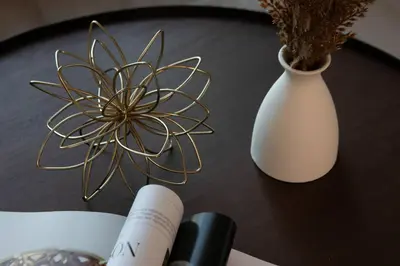 a table topped with a white vase and a book at 5-Star West Hollywood Living | Modern & Central in Los Angeles