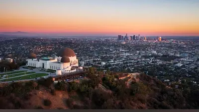 a building on top of a mountain with a city at 5-Star West Hollywood Living | Modern & Central in Los Angeles