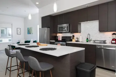 a kitchen with a large island with a white counter top at West Hollywood Luxe | 2BR/2BA Resort Style in Los Angeles