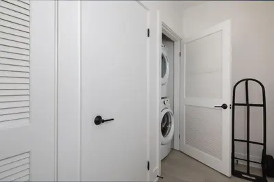 a white laundry room with a washer and dryer at West Hollywood Luxe | 2BR/2BA Resort Style in Los Angeles