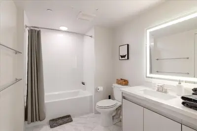 a white bathroom with a toilet and a sink at Santa Monica 1BR apt with Parking in Los Angeles