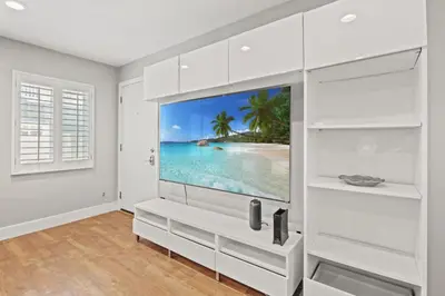 a living room with a large tv on a wall at Modern 1BR • Steps to Venice Beach in Los Angeles