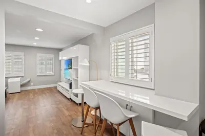 a white kitchen with white chairs and a table at Modern 1BR • Steps to Venice Beach in Los Angeles