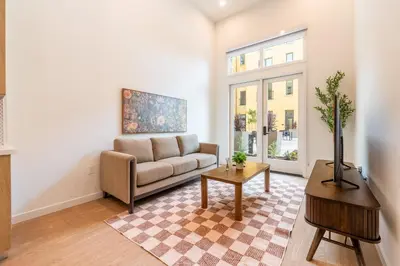 a living room with a couch and a table at The Village Collection with Gym Pool and Spa in Montclair