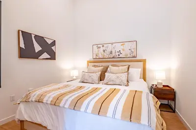 a bedroom with a large bed with two lamps at The Village Collection with Gym Pool and Spa in Montclair
