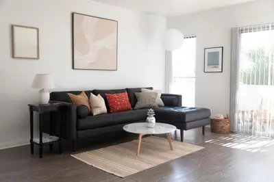 a living room with a black couch and a table at King Bed, Gym, Hot Tub, Parking in Thousand Oaks