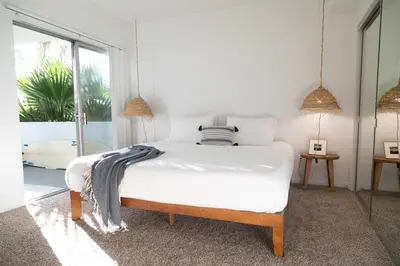 a bedroom with a white bed with a blanket on it at King Bed, Gym, Hot Tub, Parking in Thousand Oaks