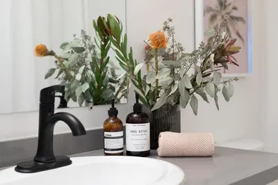 two bottles of wine on a bathroom sink with flowers at King Bed, Gym, Hot Tub, Parking in Thousand Oaks