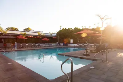 a large swimming pool with chairs and an umbrella at King Bed, Gym, Hot Tub, Parking in Thousand Oaks