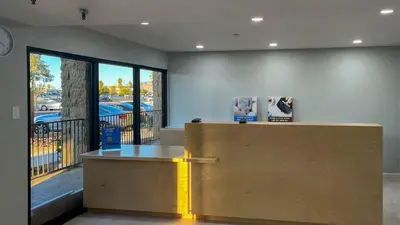 a lobby with a desk and a large window at Studio 6 Victorville Green Tree Bvld in Victorville