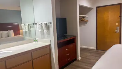 a bathroom with a sink and a tv in it at Studio 6 Victorville Green Tree Bvld in Victorville