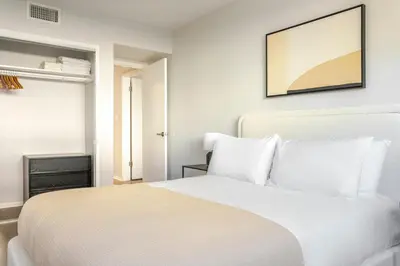 a bedroom with a white bed with a picture on the wall at Blueground Westwood balcony nr UCLA LAX-1397 in Los Angeles