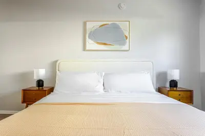 a bedroom with a white bed with two night stands at Blueground Westwood balcony nr UCLA LAX-1397 in Los Angeles