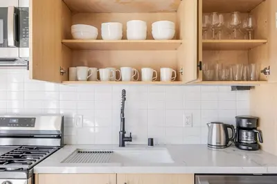 a kitchen with a sink and cabinets with dishes at Blueground East Hollywood balcony nr Echo Park LAX-1336 in Los Angeles