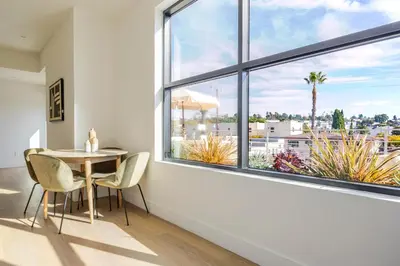 a dining room with a table and chairs and a large window at Blueground East Hollywood rooftop nr Griffith Park LAX-1337 in Los Angeles