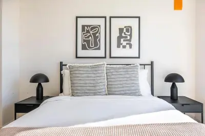 a bedroom with a white bed with two black lamps at Blueground East Hollywood rooftop nr Griffith Park LAX-1337 in Los Angeles