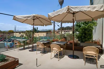 a patio with tables and chairs and umbrellas at Blueground East Hollywood rooftop nr Griffith Park LAX-1337 in Los Angeles