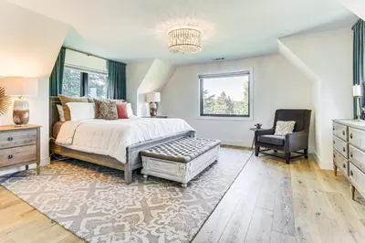 a bedroom with a bed and a chair at Walk to Lake Arrowhead Village! Home with Lake Views in Lake Arrowhead