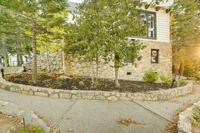 a stone house with trees in the front of it at Steps to Lake Arrowhead Village Chic Apartment in Lake Arrowhead