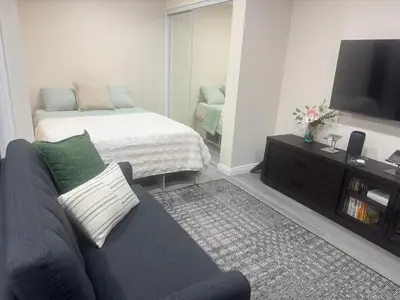 a living room with a couch and a bed at Peaceful Cottage in Vermont Knolls in Los Angeles