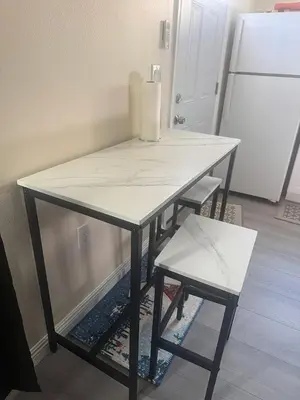 a kitchen table with a white counter top and a stool at Peaceful Cottage in Vermont Knolls in Los Angeles