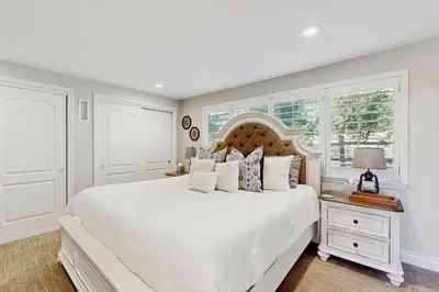 a white bedroom with a large bed and a window at Surreal Feel Lakeview #B (Upstairs) in Lake Arrowhead