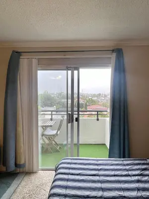 a bedroom with a bed and a sliding glass door at Modern West LA Studio with Pool, Gym & Parking in Los Angeles