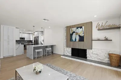 a living room with a fireplace and a kitchen at NEW Remodeled Northridge 5 Bedroom Near CSUN & Sherwood Forest in Northridge