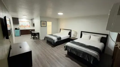 a hotel room with two beds and a desk at Florentine Motel And Studio in Bell