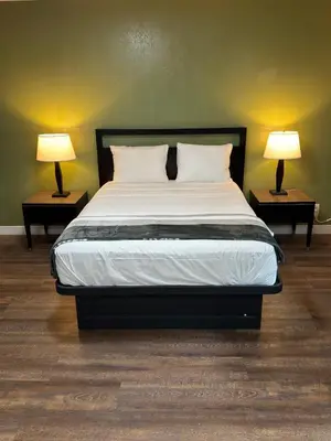 a bedroom with a bed with two lamps on tables at Florentine Motel And Studio in Bell
