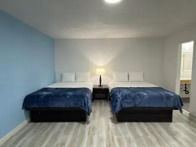 two beds in a room with blue walls at Florentine Motel And Studio in Bell