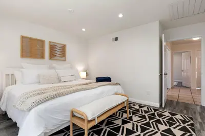 a large white bedroom with a large bed and a rug at Cozy & Bright Santa Clarita Retreat in Santa Clarita