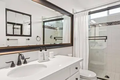 a bathroom with a sink and a toilet and a mirror at Goode HOMES Stunning Home w/ Beautiful Backyard in Santa Clarita