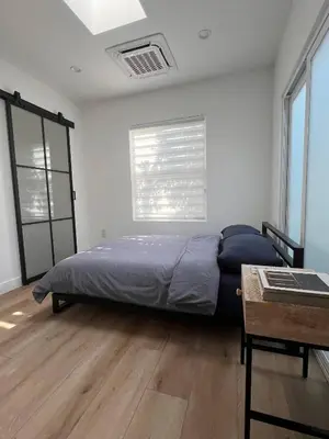 a bedroom with a bed and a table and a window at Newly Built Private Guest House in Glendale
