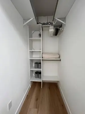 a walk in closet with white shelves and wood floors at Newly Built Private Guest House in Glendale