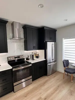 a kitchen with black cabinets and stainless steel appliances at Newly Built Private Guest House in Glendale