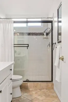 a white bathroom with a shower and a toilet at GOODE.HOMES | Luxury Home w/ Beautiful Garden in Santa Clarita