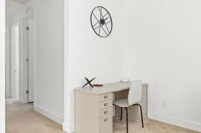 a white desk with a chair and a clock on a wall at Luxury Mountain View Home w/ large backyard in Santa Clarita