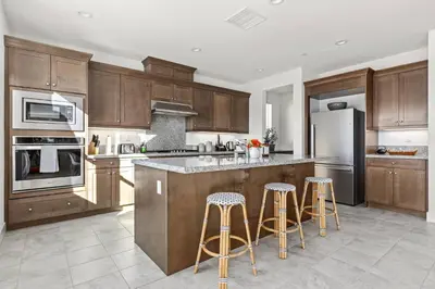 a kitchen with wooden cabinets and stainless steel appliances at Luxury Mountain View Home w/ large backyard in Santa Clarita