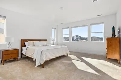 a white bedroom with a bed and windows at Scenic Mountain View Home with Spacious Yard in Santa Clarita