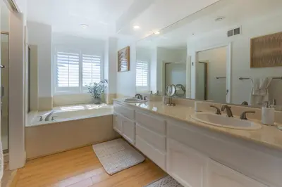 a bathroom with two sinks and a tub and a large mirror at Goode.Homes Hilltop Home w. private pool/spa in Newhall