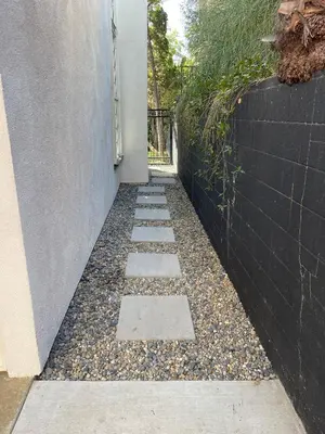 a stone walkway next to a wall with a fence at Large 6-bedroom house w/jacuzzi in Monterey Park
