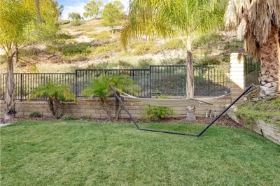a hammock in a yard next to a fence at Mountain View Home with Pool & Fenced-In Yard in Santa Clarita