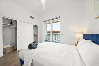 a white bedroom with a large bed and a tub at Modern Getaway Heart of Long Beach in Long Beach