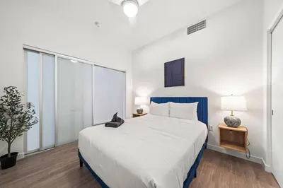 a bedroom with a large bed with a blue headboard at Modern Getaway Heart of Long Beach in Long Beach
