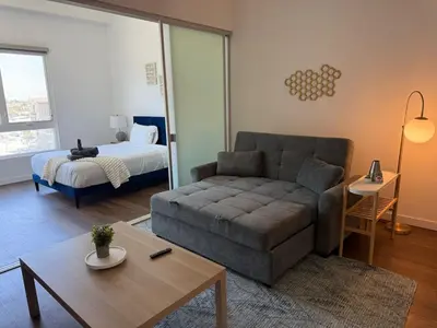 a living room with a couch and a bed at Modern Getaway Heart of Long Beach in Long Beach